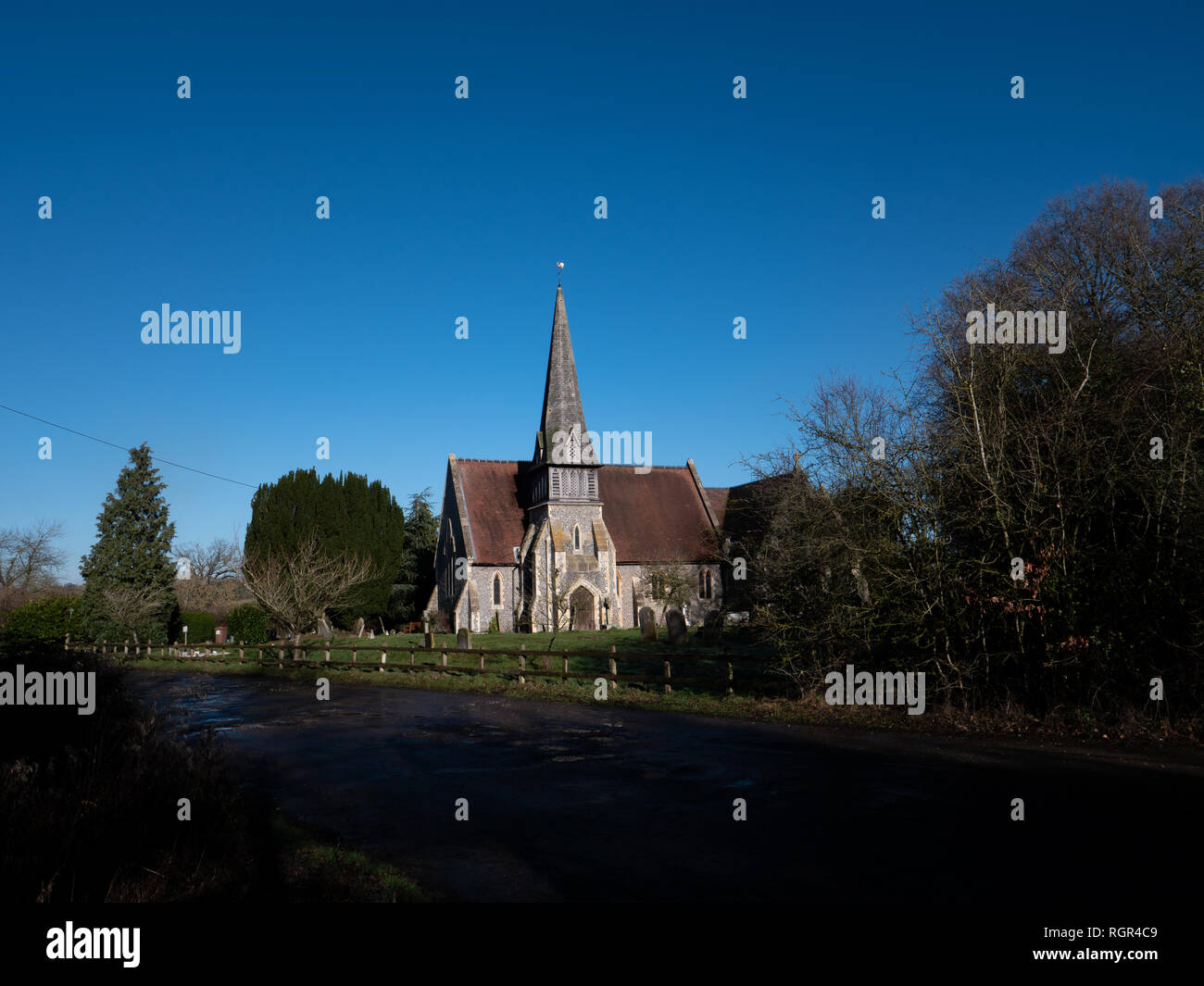 English country church with spire against blue sky. St James Barkham