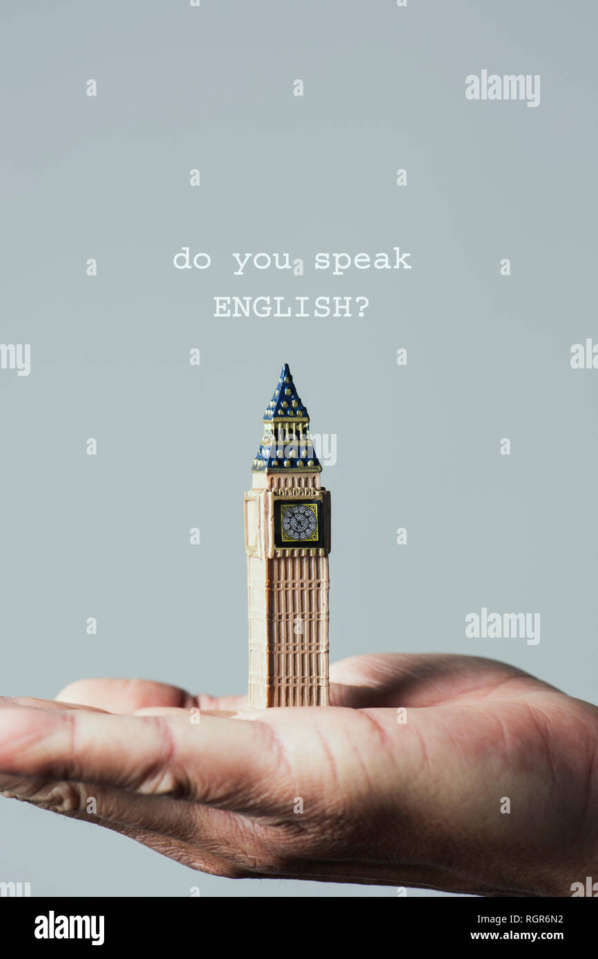 closeup of the miniature of the Clock Tower of the Palace of Westminster in London, United Kingdom, on the hand of a caucasian man, and the question d Stock Photo