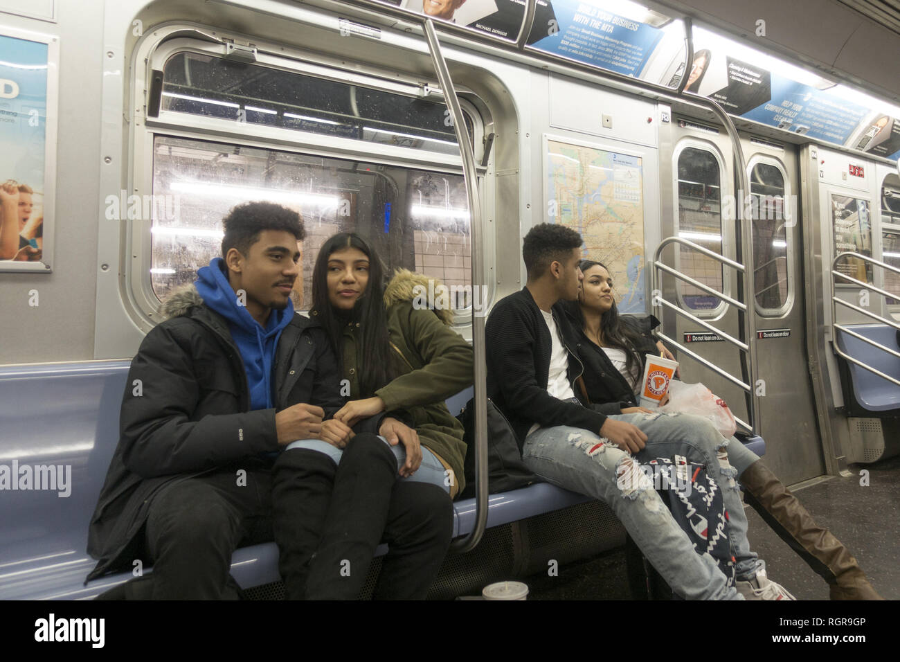 Young couples ride an R train in Brooklyn after school in Brooklyn, New