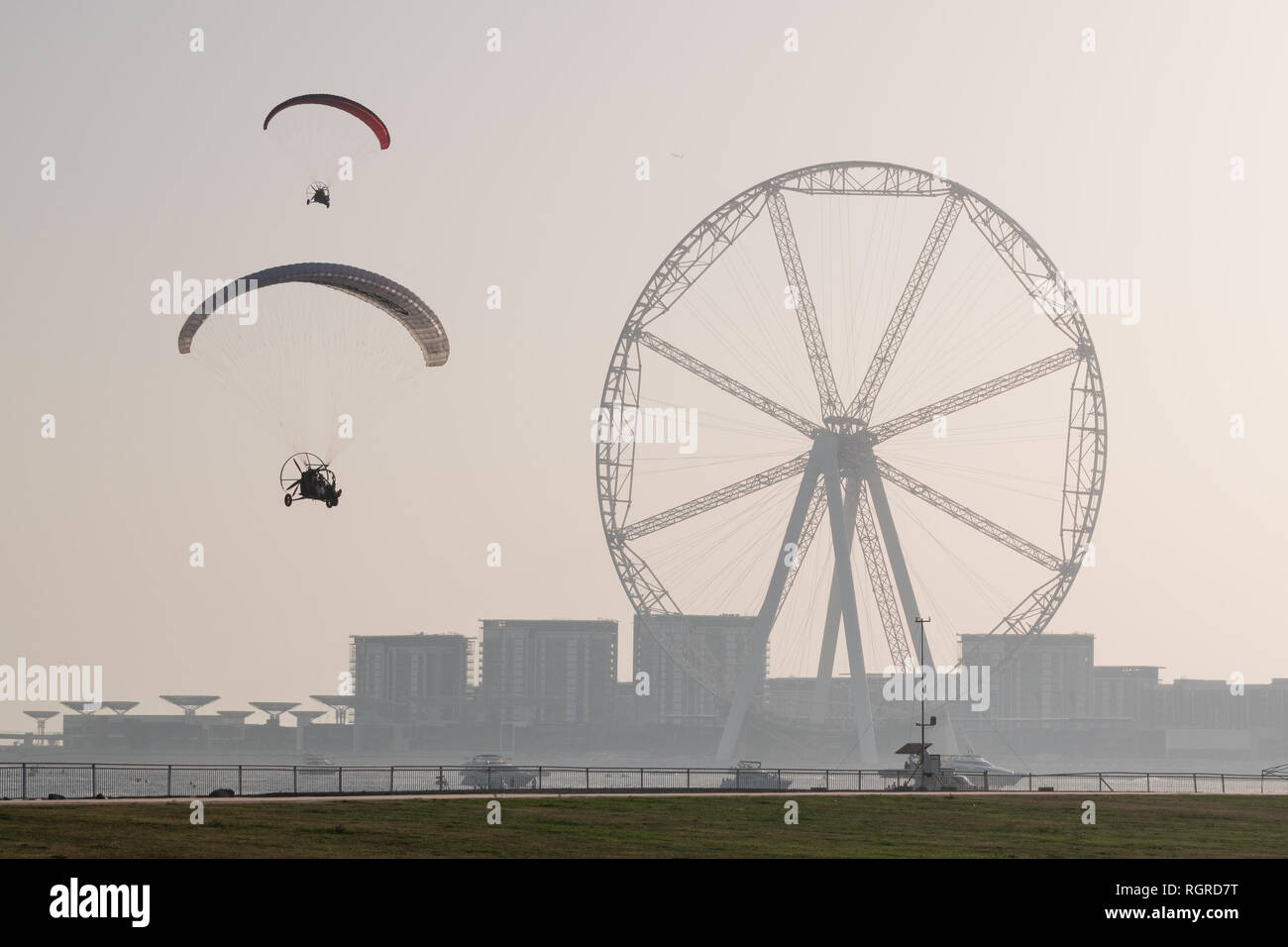 DUBAI, UAE - February 16, 2018:  Two parahubs with Dubai Eye and the huge Ferris Wheel in background at dusk, Dubai, UAE Stock Photo