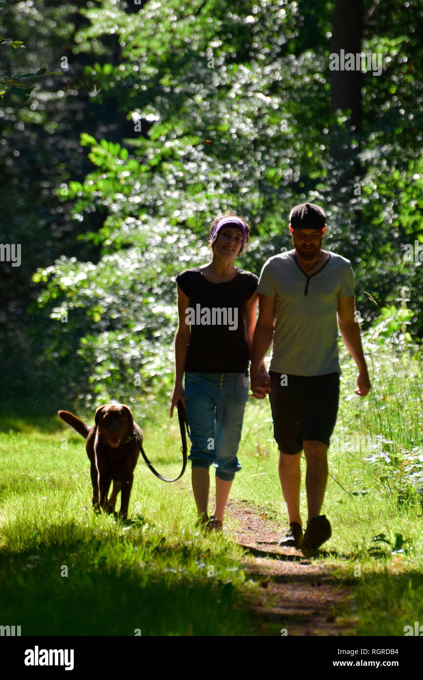 Couple walking with Labrador Retriever Stock Photo