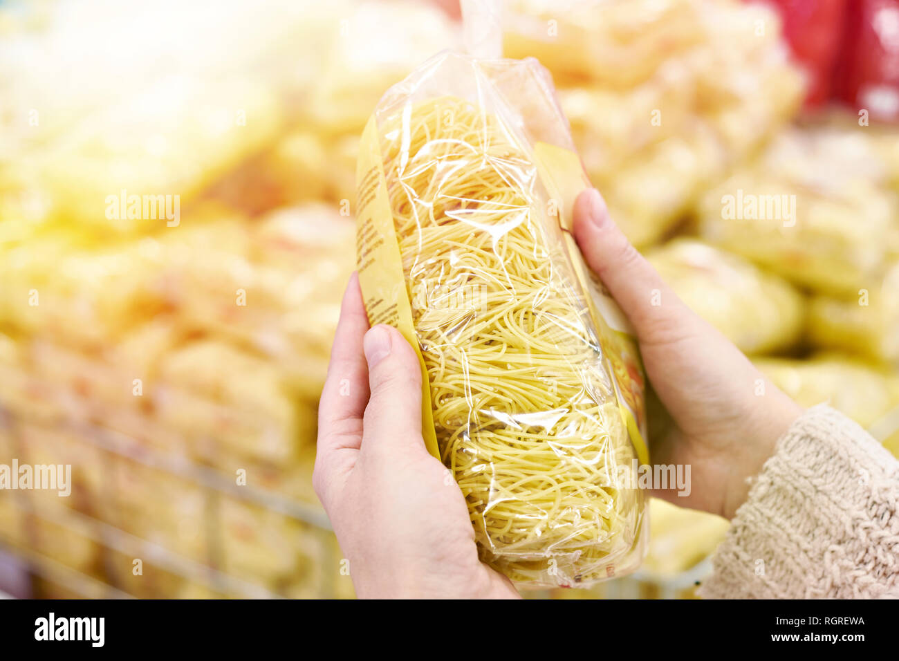 Pack of spaghetti in the hands of the buyer at the store Stock Photo