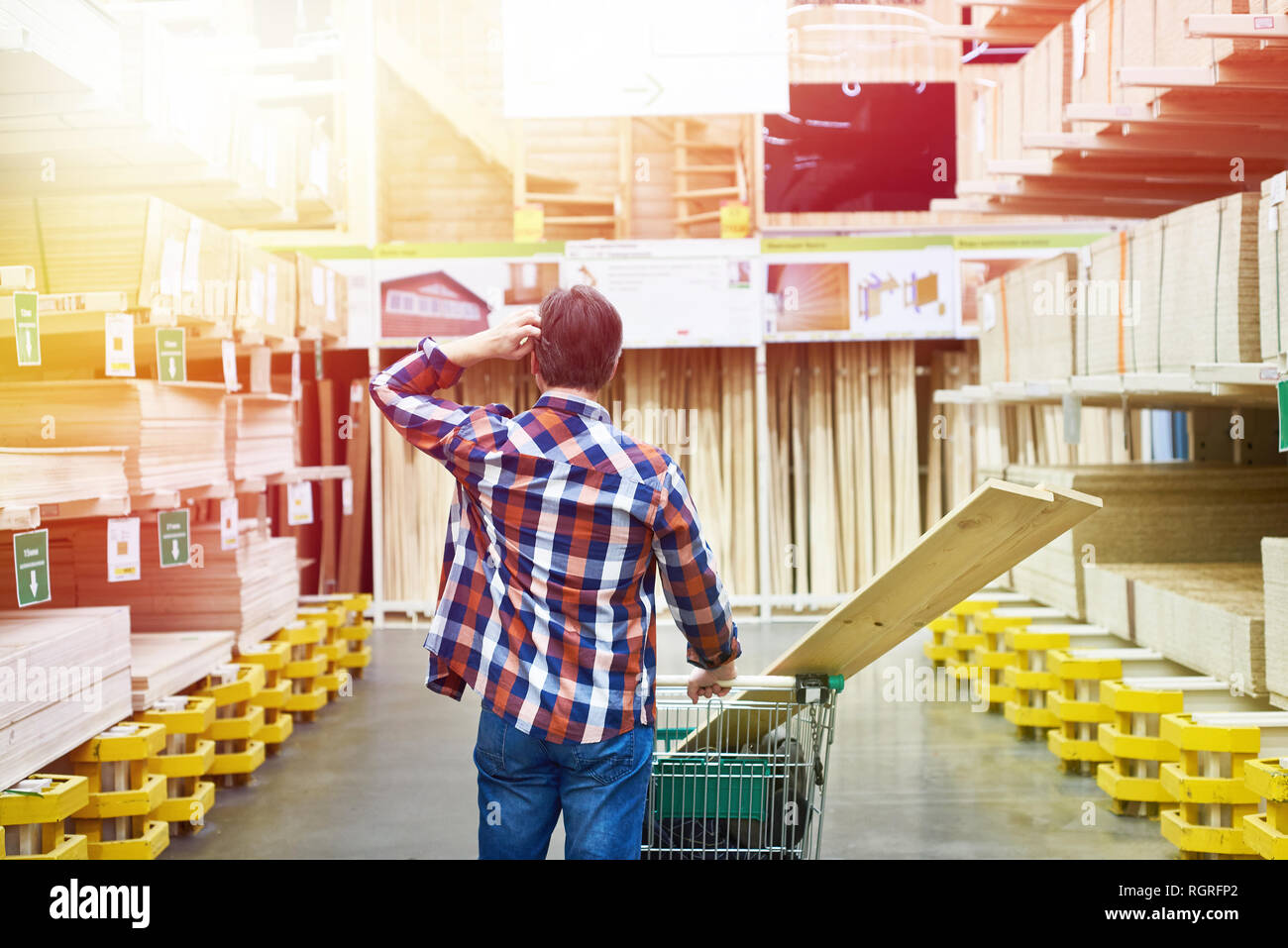 Man chooses and buys plywood and boards in a construction supermarket Stock Photo