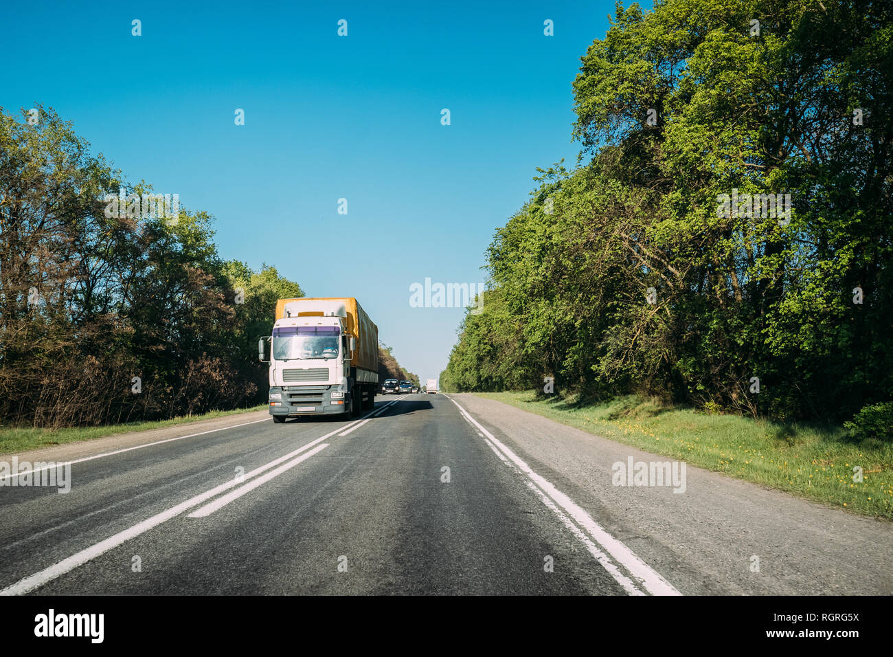 Truck In Motion On Country Road. Tractor Unit, Prime Mover, Traction Unit In Motion On Countryside Road In Europe. Business Transportation And Truckin Stock Photo