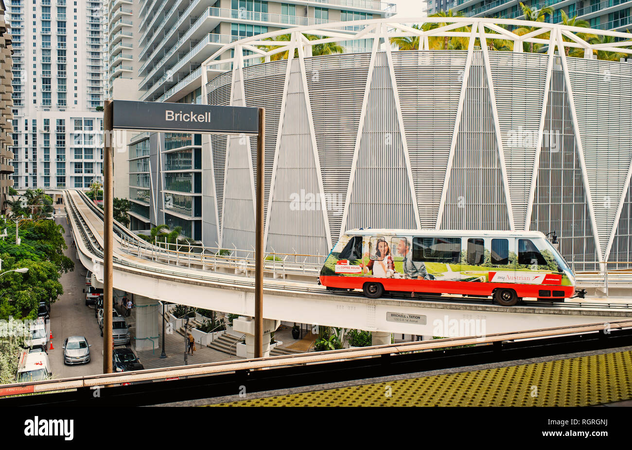 Miami, USA - October 30, 2015: train arrive at brickell station with downtown skyscrapers on urban background. Metrorail or metro rail transit system on cityscape. Metropolitan transport service. Stock Photo