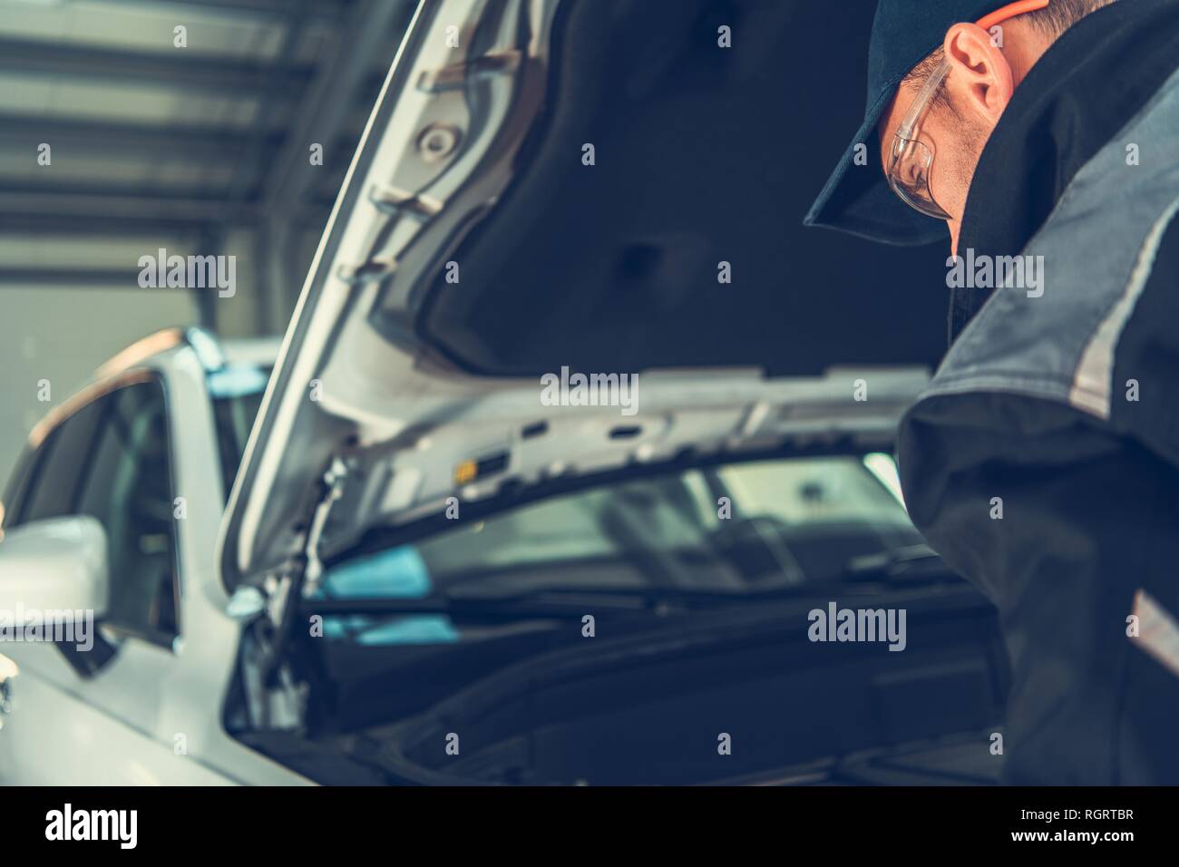 Auto Mechanic Repair Time. Caucasian Automotive Technician Looking Under Car Hood. Vehicle