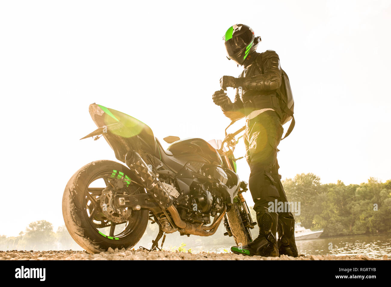 Biker man and motorcycle with river background, Rider moto trip on the ...