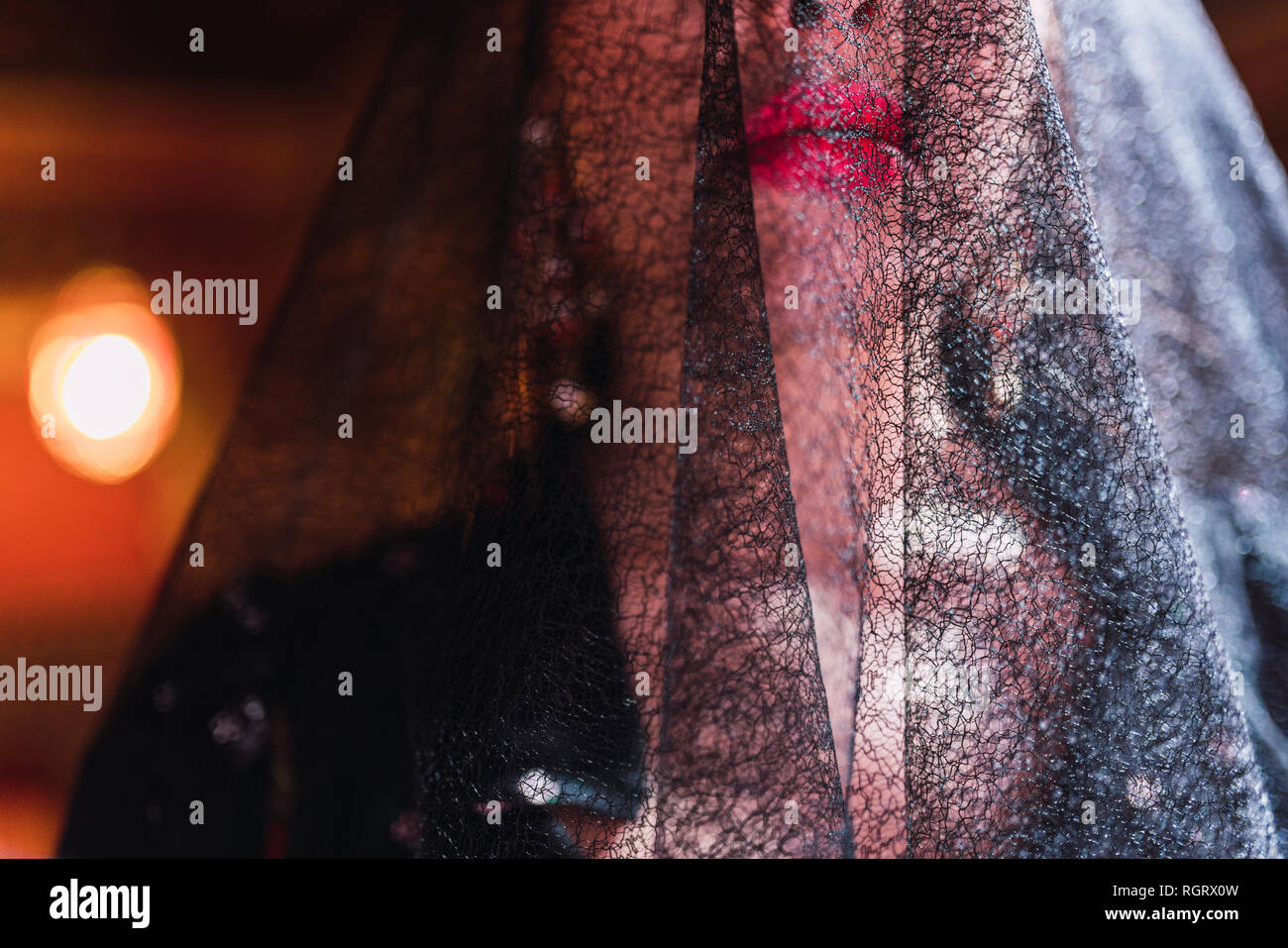 Crop lady in veil and dress on scene illuminated by lights on blurred background Stock Photo