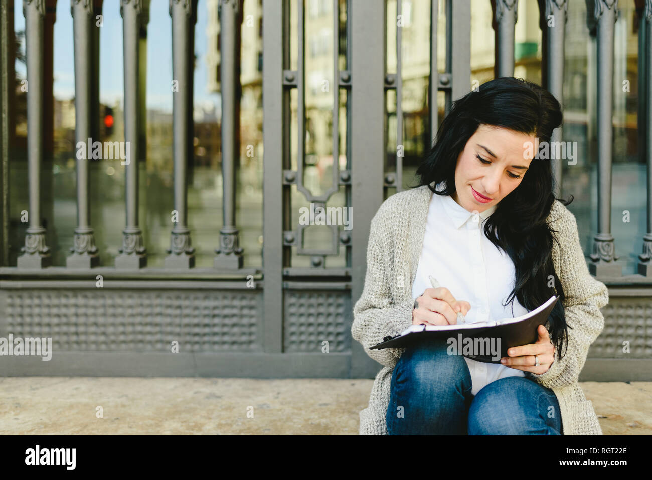 Portrait mature woman taking notes in her notebook, reading plans ...