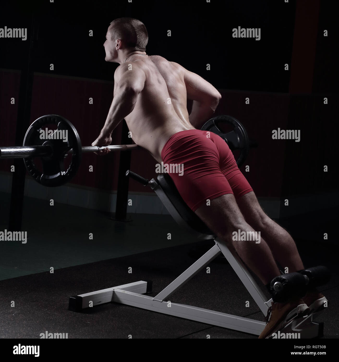 rear view .a man bodybuilder performs an exercise on the simulator ...