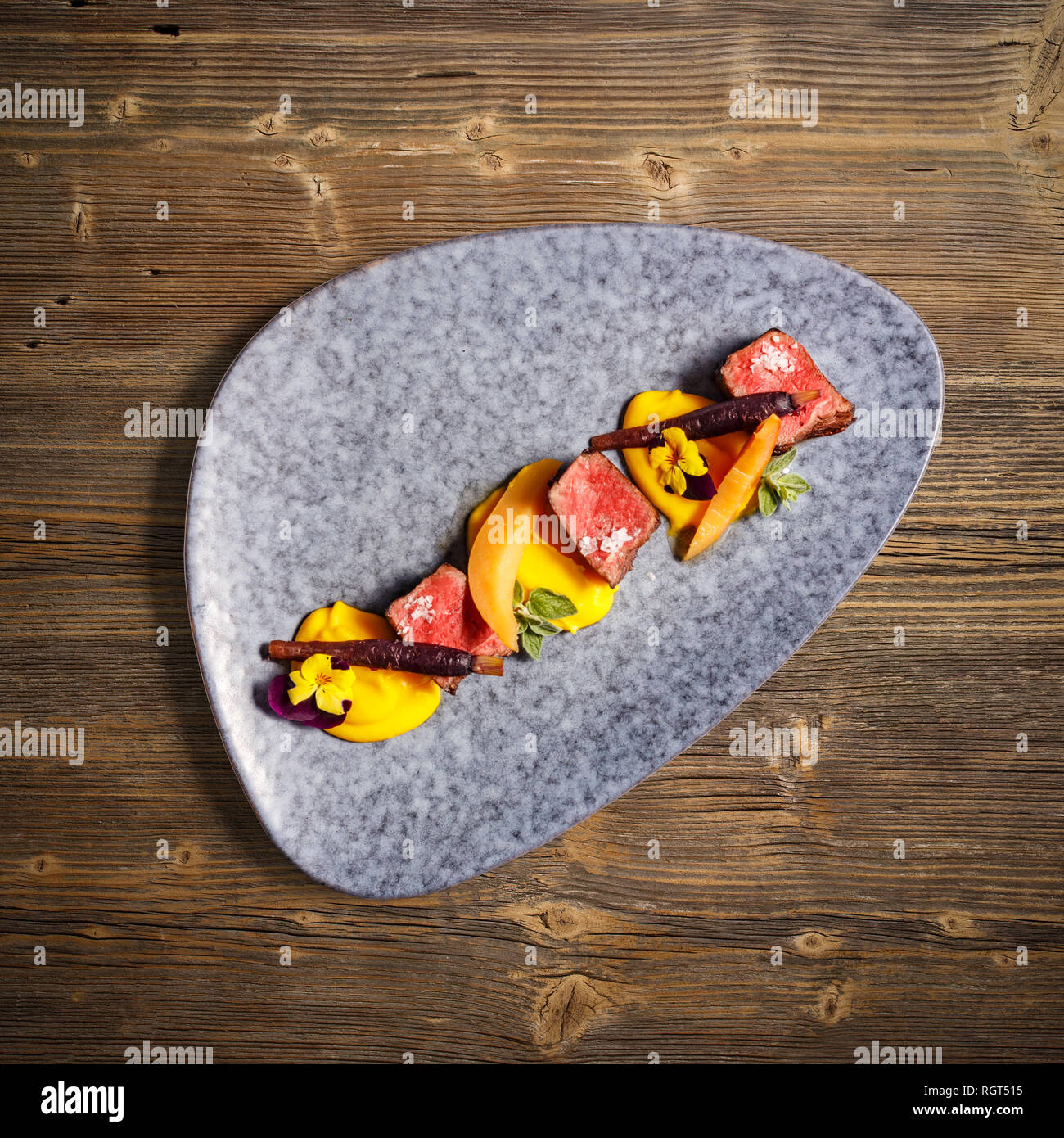 Flat lay of deer sirloin with mashed sweet potatoes on wooden background Stock Photo