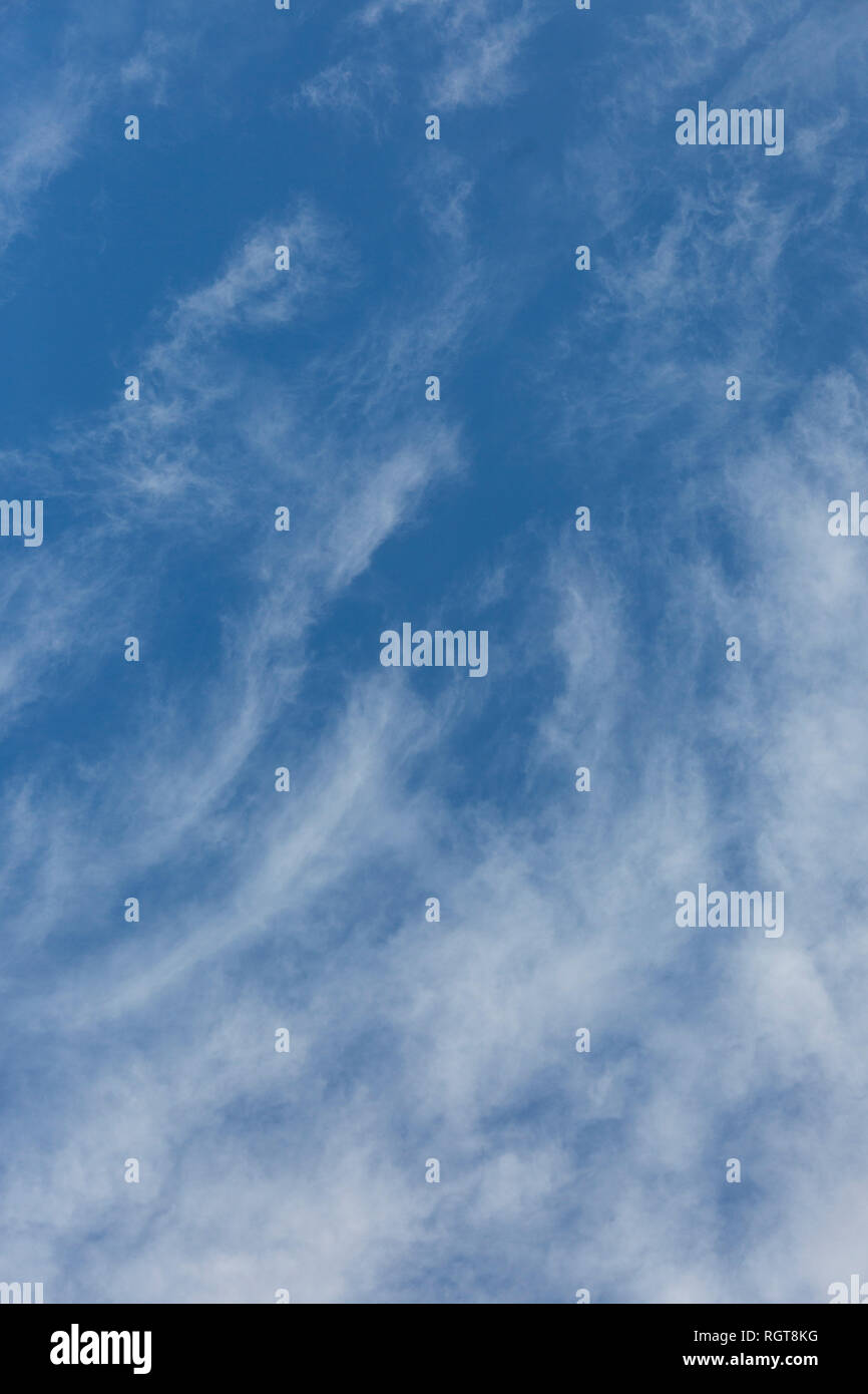 Bright Blue sunny sky with white fluffy clouds floating across on a ...