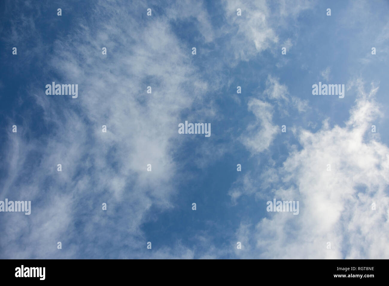 Bright Blue sunny sky with white fluffy clouds floating across on a ...
