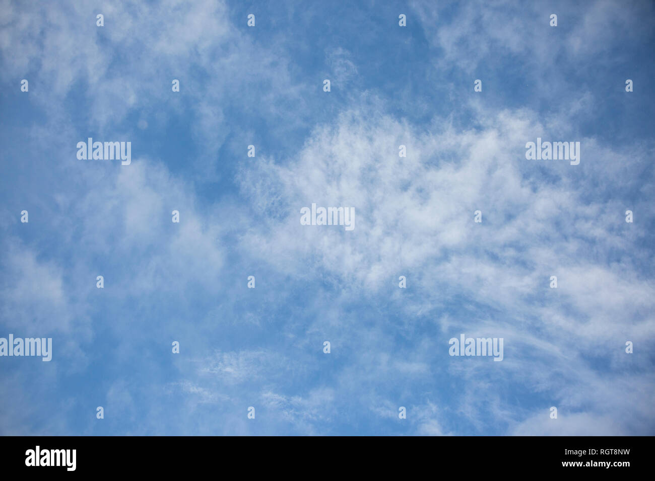 Bright Blue sunny sky with white fluffy clouds floating across on a ...