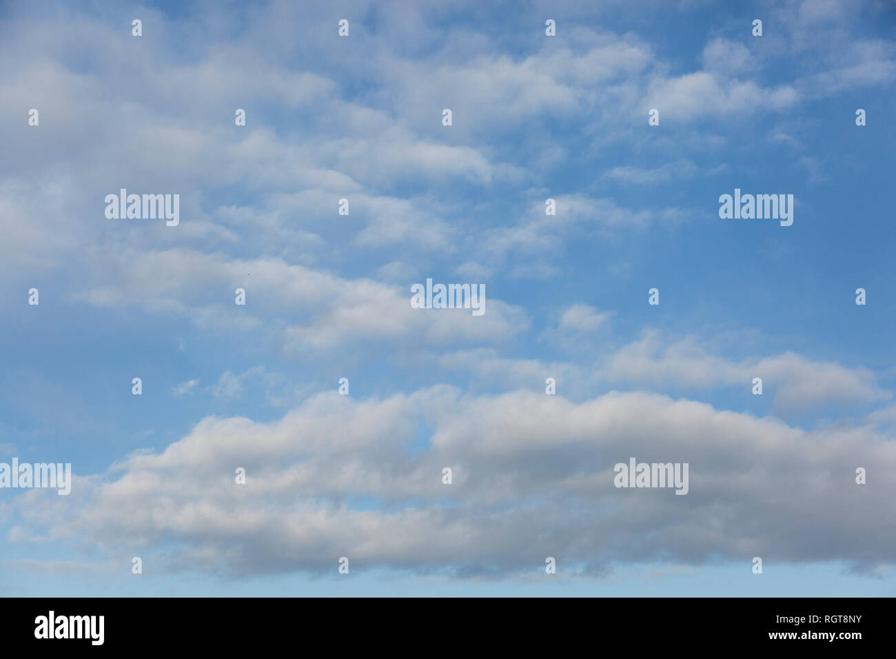 Bright Blue sunny sky with white fluffy clouds floating across on a ...