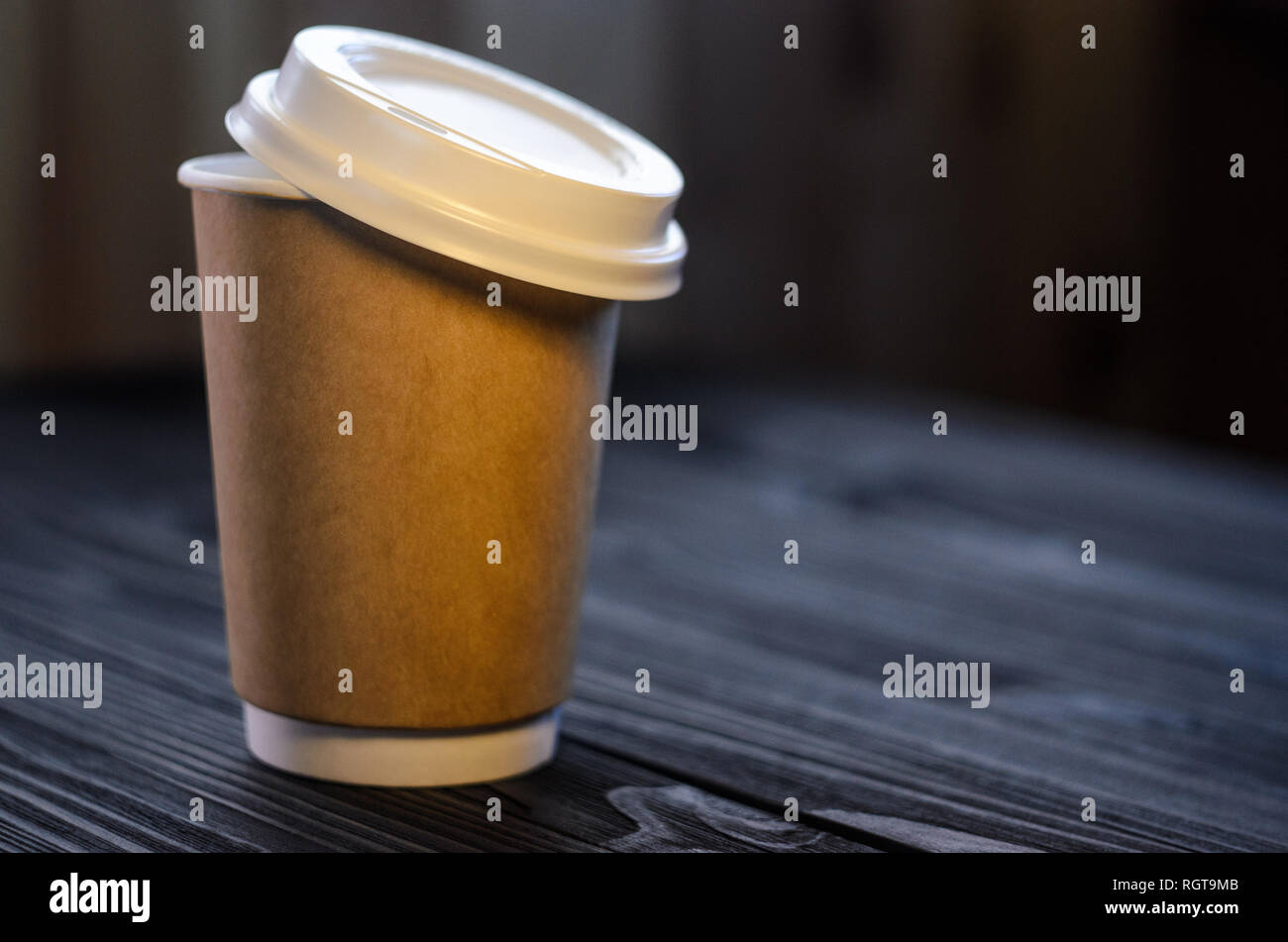 A cup of coffee on the table. Paper cup Wooden table Plastic cap Coffee Expectation. Coffee take