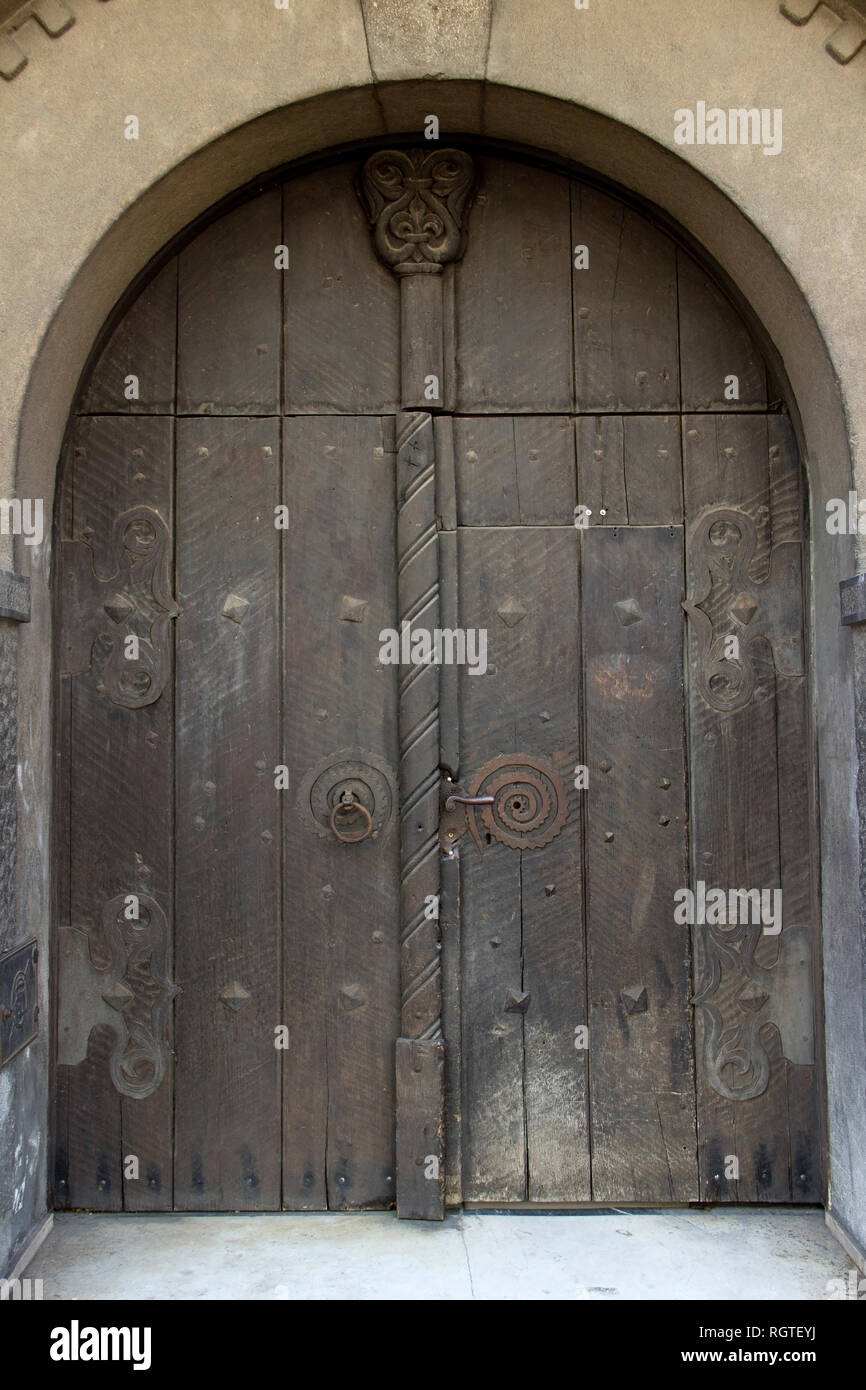 Old wooden massive door with shackles Stock Photo