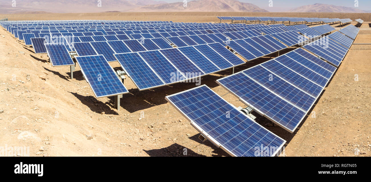 Hundreds solar energy modules or panels rows along the dry lands at Atacama Desert, Chile. Huge Photovoltaic PV Plant in the middle of the desert Stock Photo