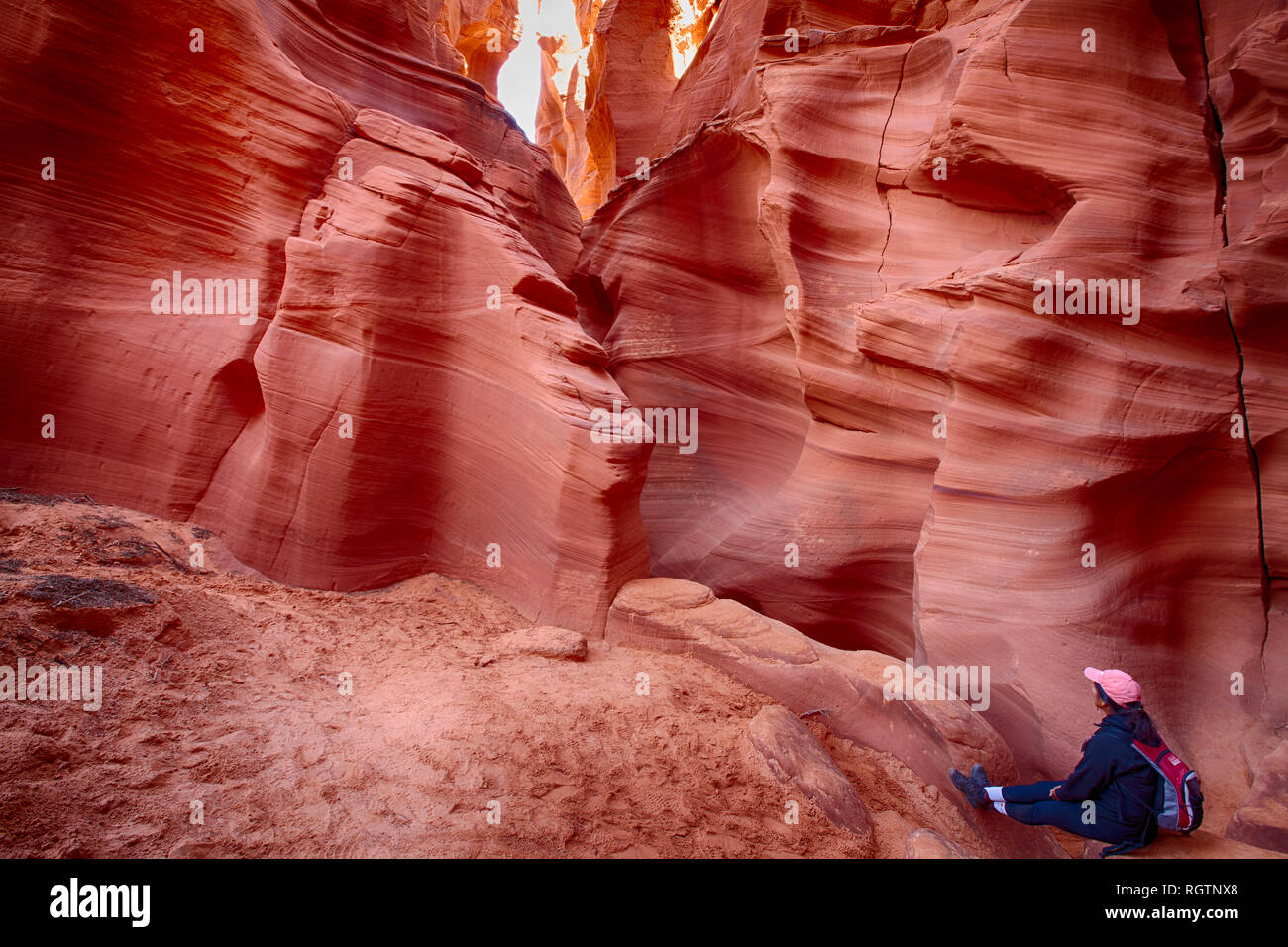 Woman hiker looking at walls in a slot Canyon in page Arizona Stock Photo