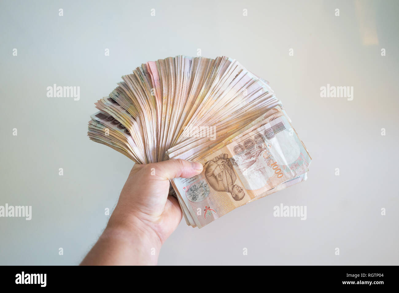 hands counting of thousansds Thai baht money.Close up Human counting Thai banknote, richman count and holding hundred baht bills on wood table, with s Stock Photo