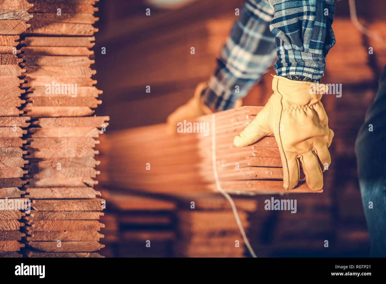 Raw Hardwood Flooring Panels Moving by Caucasian Worker. Woodwork Industry. Stock Photo