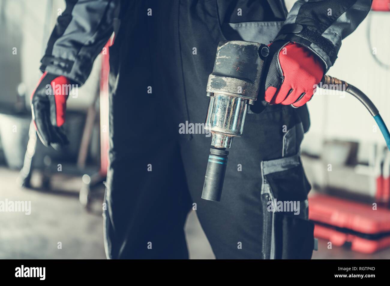 Car Mechanic with Air Impact Wrench Pneumatic Gun. Automotive Industry