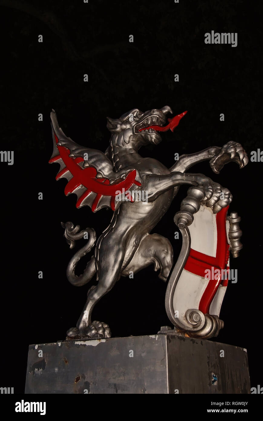 Dragon statue in London, United Kingdom. Dragon with shield on dark sky