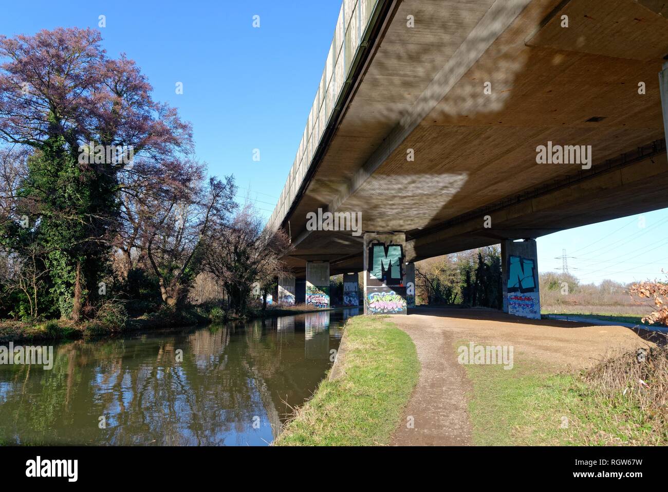 The elevated section of the M25 motorway passing over the River Wey navigation canal New Haw Surrey England UK Stock Photo