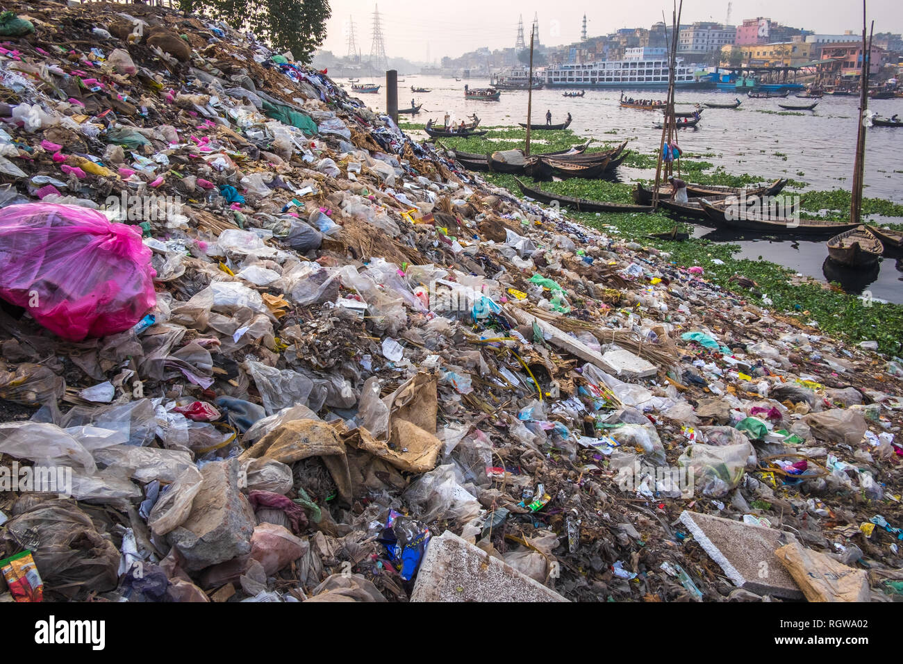 garbage and plastic pollution on the river bank in Dhaka, Bangladesh, riverside and boats in the background Stock Photo