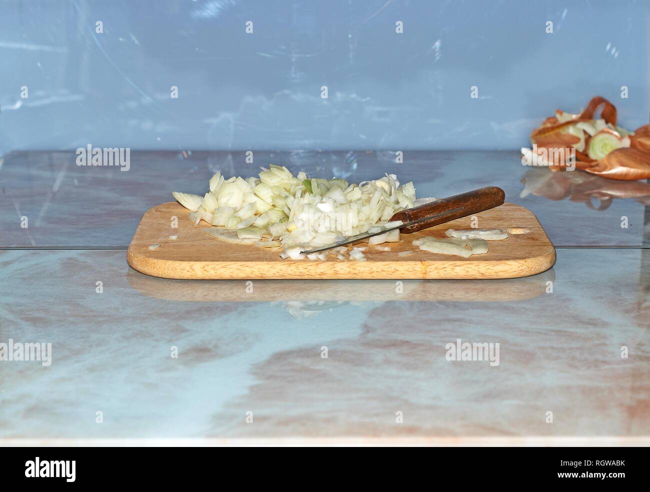 Chef slicing Onion, Allium cepa on the cutting board with a knife. Stock Photo