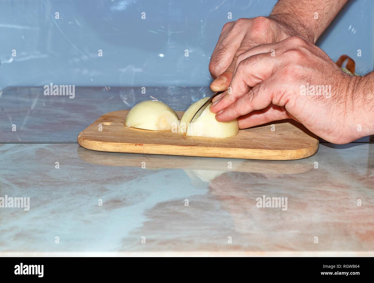 Chef slicing Onion, Allium cepa on the cutting board with a knife Stock ...