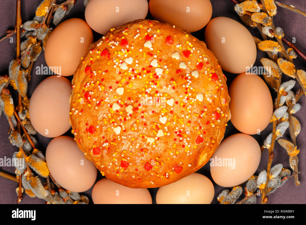 Easter bread in a circle of Easter eggs and a willow branch, a texture