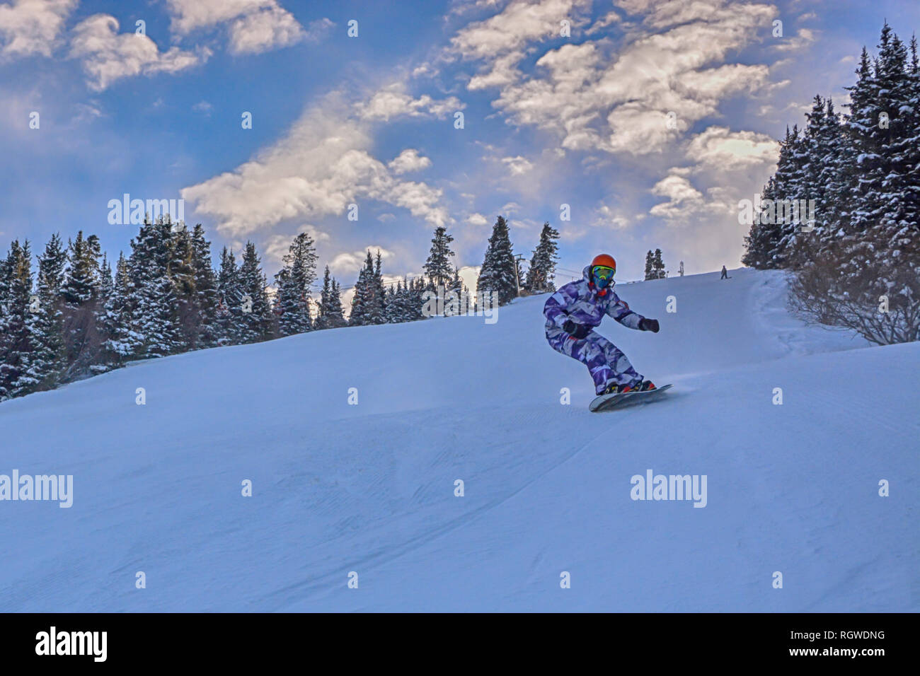 Young snowboarder sliding down snowy slope on mountain at winter resort  6983172 Stock Photo at Vecteezy