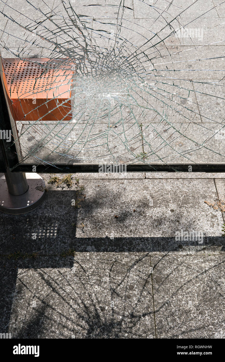 Vandalism concept. Damaged glass at bus stop shelter. Social problems Stock Photo