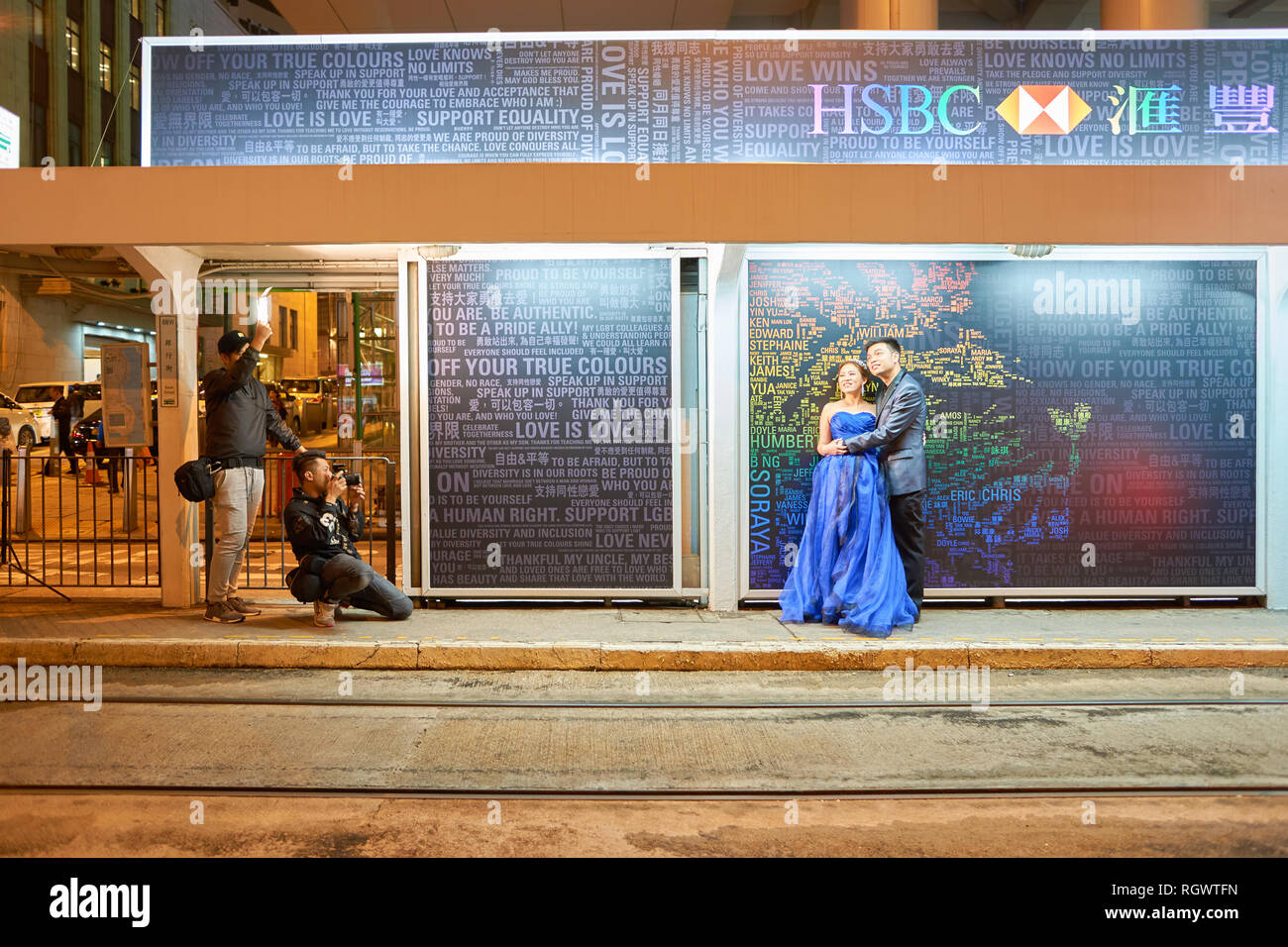 HONG KONG - CIRCA NOVEMBER, 2016: photographer taking shots of couple in Hong Kong at nighttime. Hong Kong  is an autonomous territory on the Pearl Ri Stock Photo