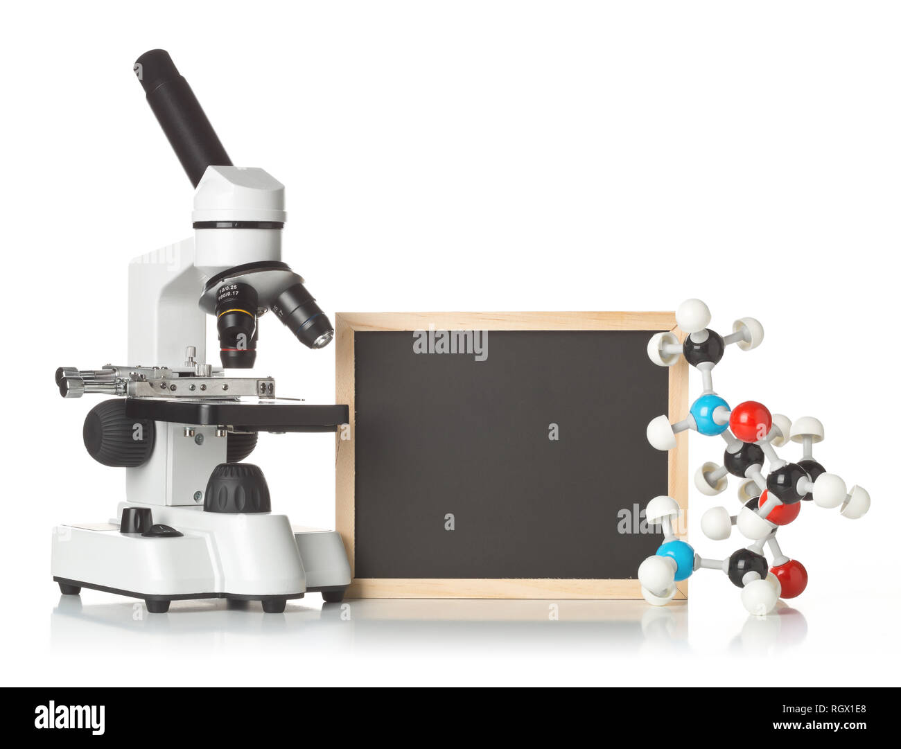 Blank, empty, black chalkboard with microscope and molecule model over white background - science teaching concept Stock Photo