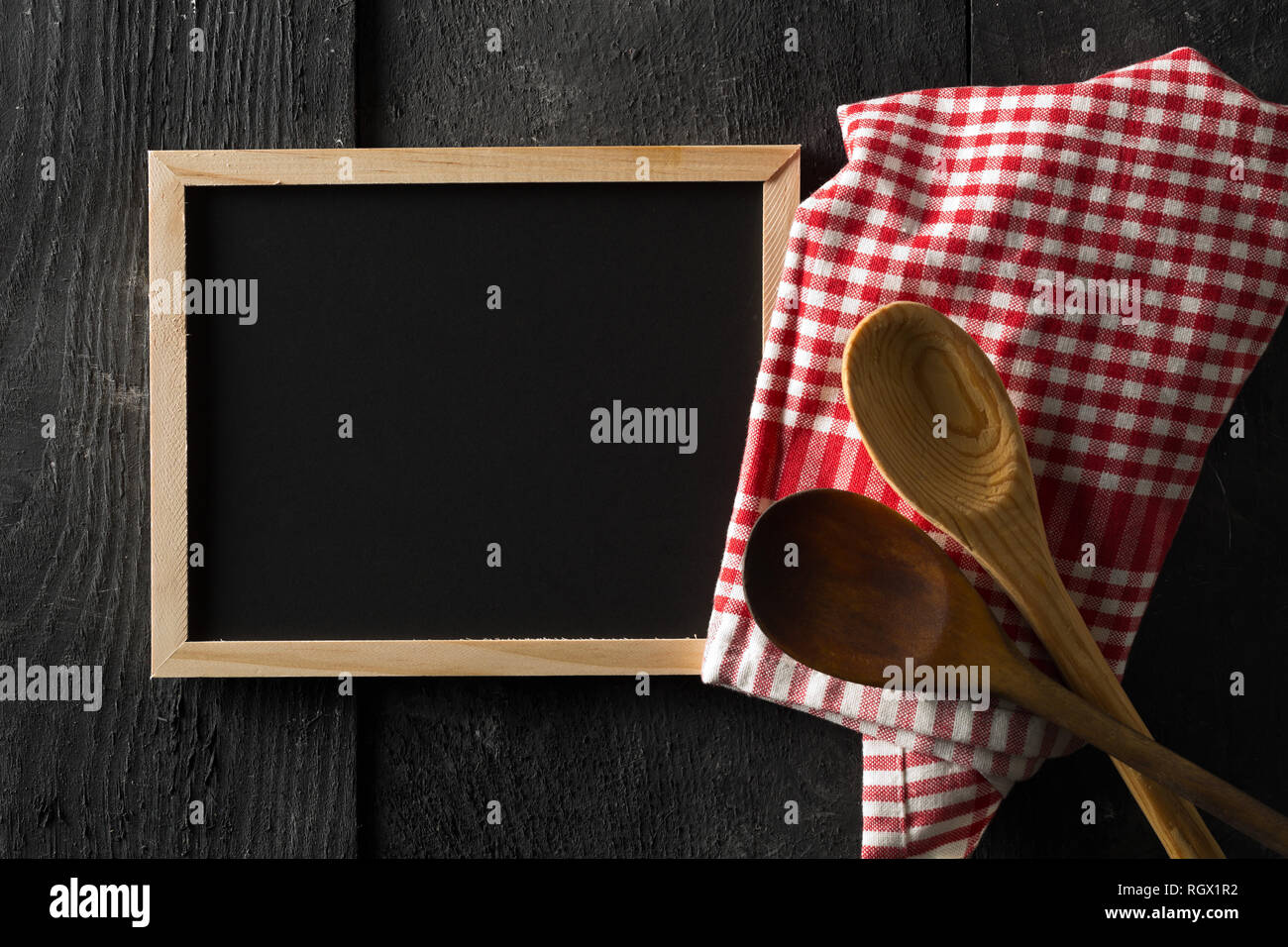 Blank Empty Black Chalkboard With Wooden Cooking Spoons And Red