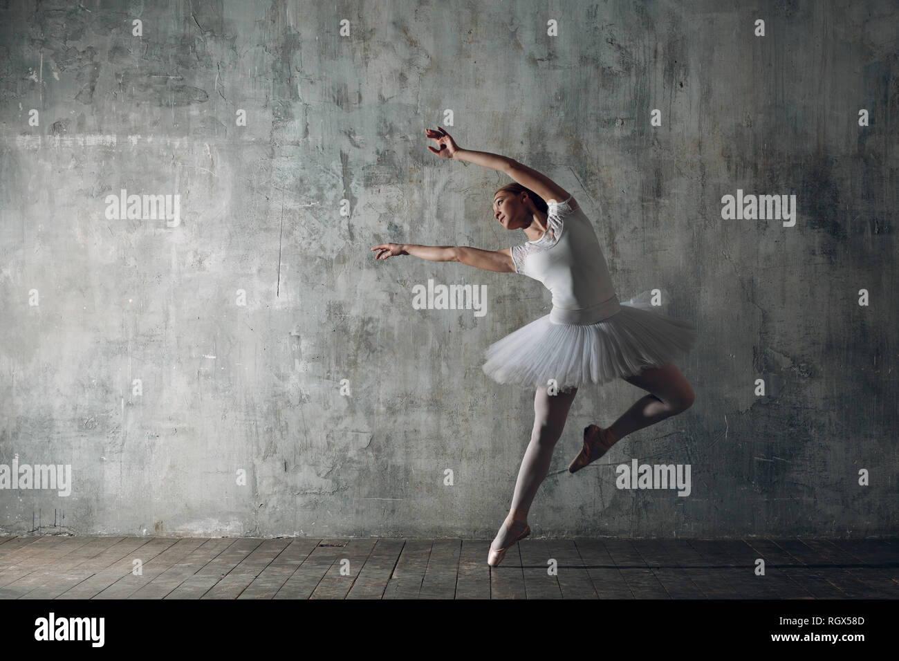 Ballerina female. Young beautiful woman ballet dancer, dressed in professional outfit, pointe shoes and white tutu. Stock Photo