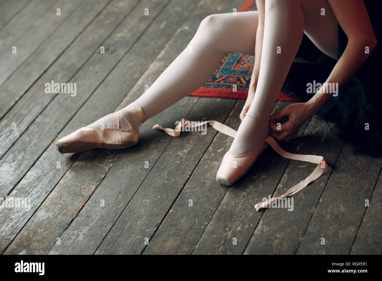 Ballerina prepare to performance. Young beautiful woman ballet dancer, dressed in professional outfit, pointe shoes and black tutu. Stock Photo