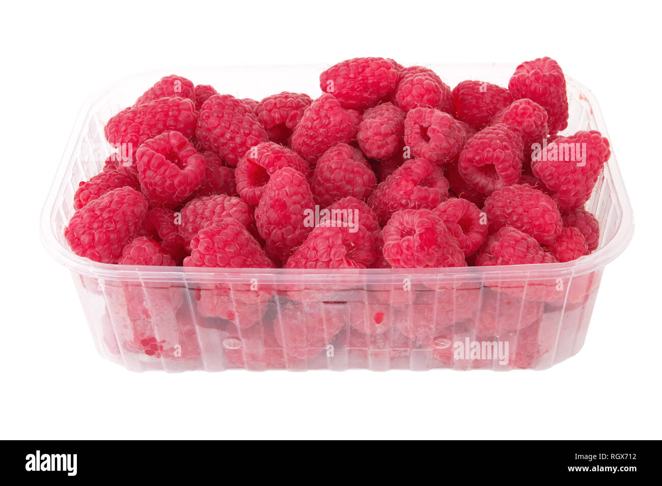 Fresh raspberries in the plastic box over white background Stock Photo ...