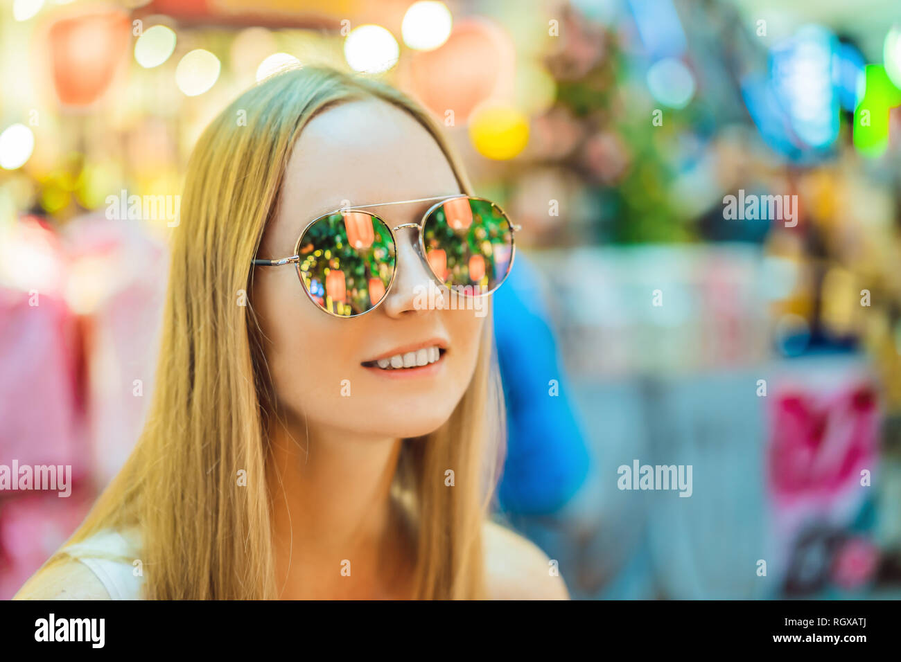 Woman celebrate Chinese New Year look at Chinese red lanterns. Chinese lanterns are reflected in glasses Stock Photo