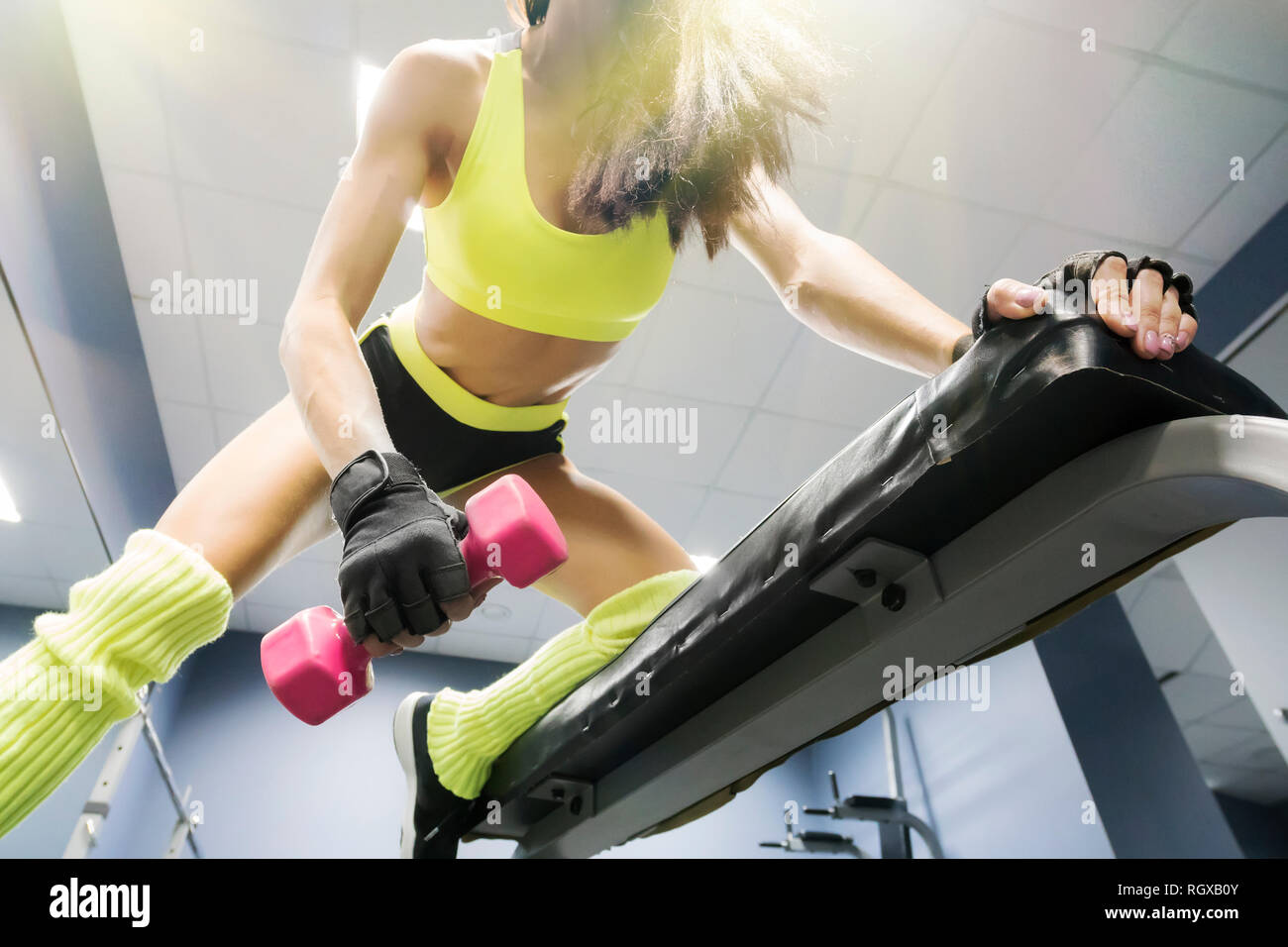 Strong young brunette woman doing push ups exercise with pink dumbbells ...
