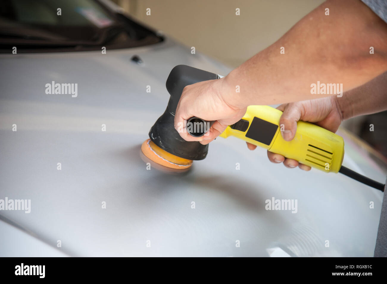Man polish a silver car with orbital polisher Stock Photo Alamy