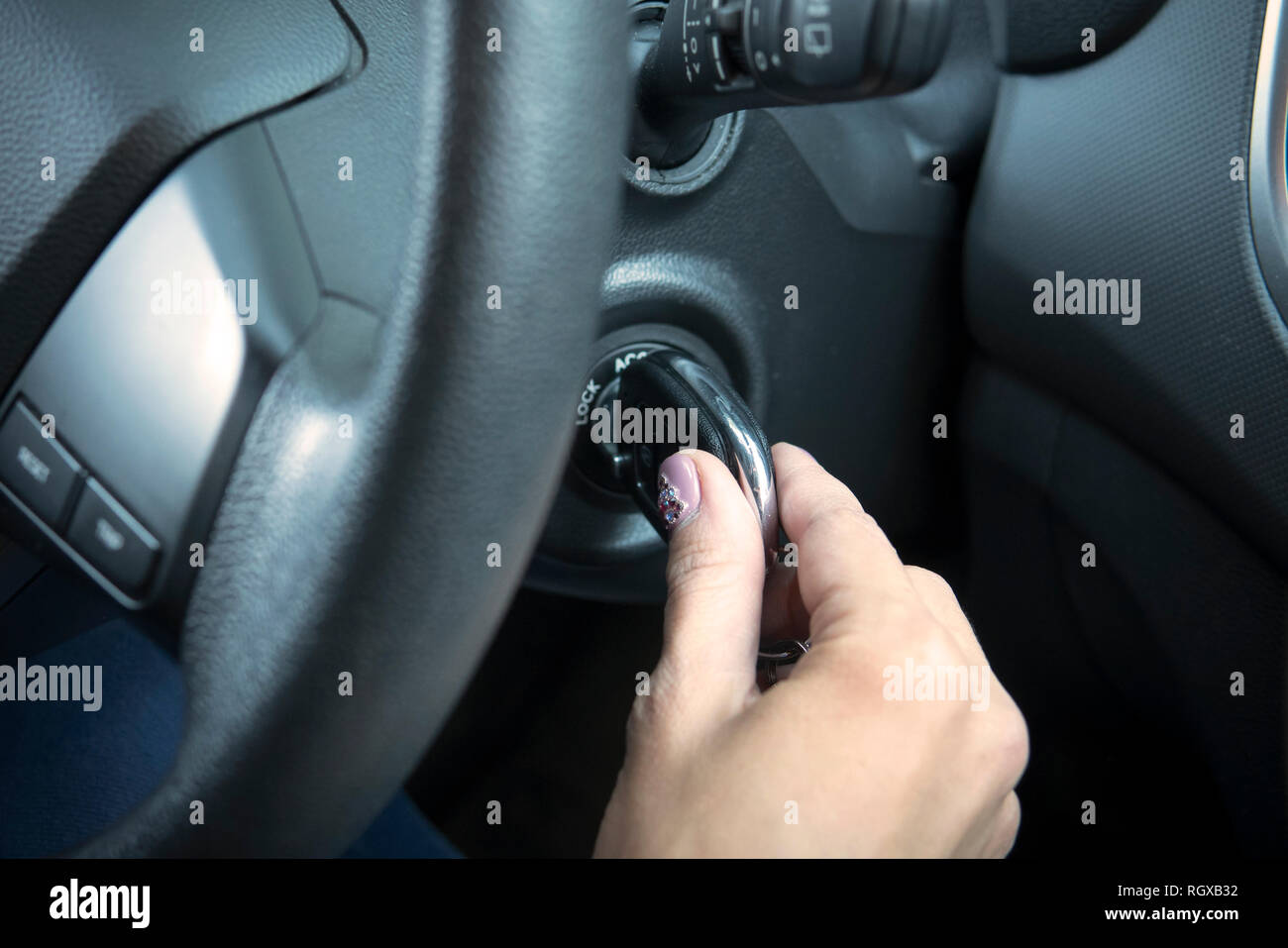 Woman driver starting the car. Moment of inserting the key into vehicle