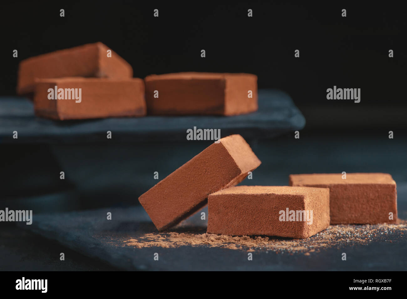 Soft chocolate in cocoa powder on a black background with copy space ...
