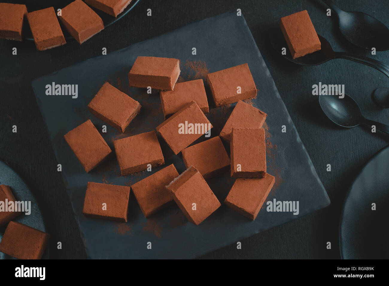 Soft chocolate in cocoa powder on a black background with copy space