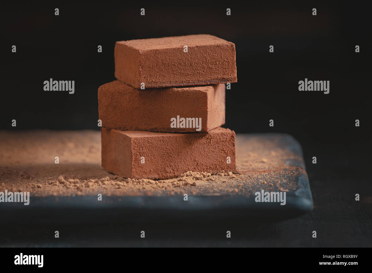 Soft chocolate in cocoa powder on a black background with copy space ...