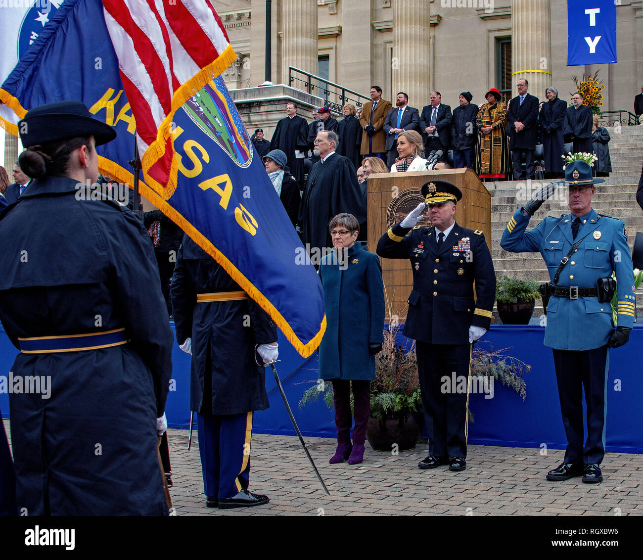 Topeka, Kansas, USA, January 14, 2019 Governor Laura Kelly stands while Major General Lee Tafanelli the Adjutant General of Kansas and Colonel Mark Bruce the Superintendent of the Kansas Highway patrol salute the colors during the  Assumption of Command ceremony at Kelly's inaugural Credit: Mark Reinstein/MediaPunch Stock Photo