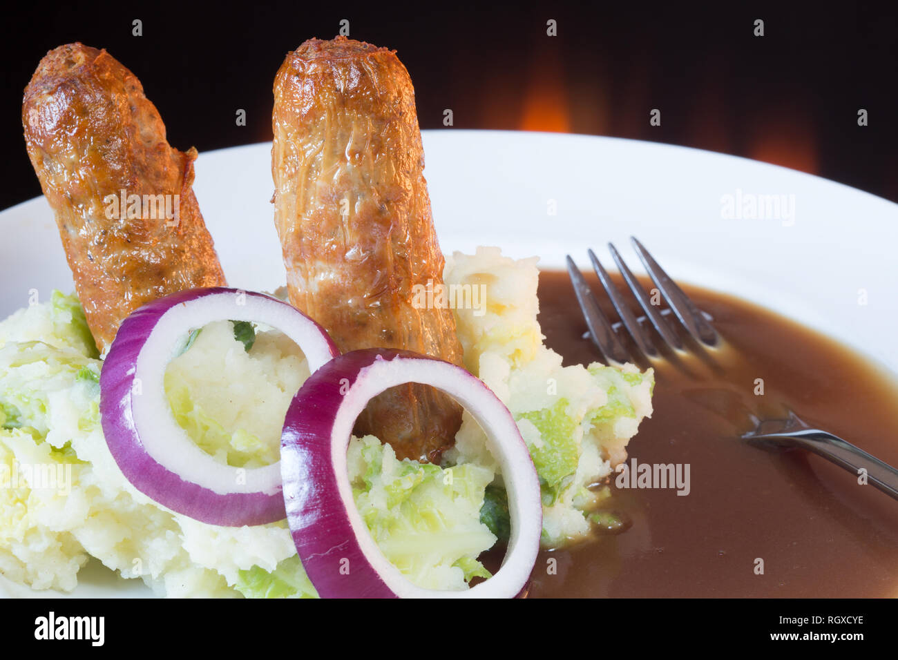 Classic English pub dish of Sausage and mash with gravy sauce. Stock Photo