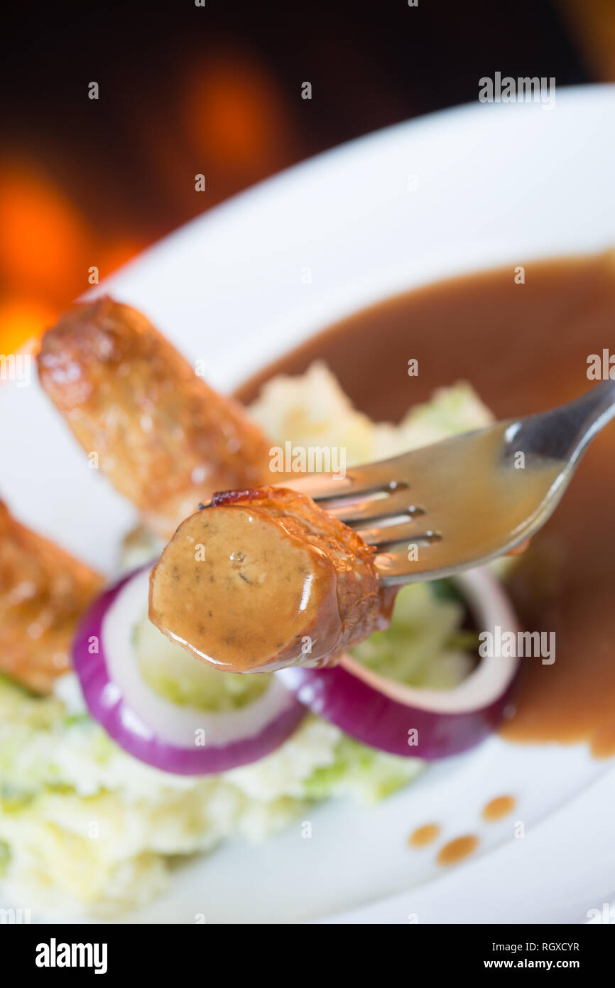 Classic English pub dish of Sausage and mash with gravy sauce Stock